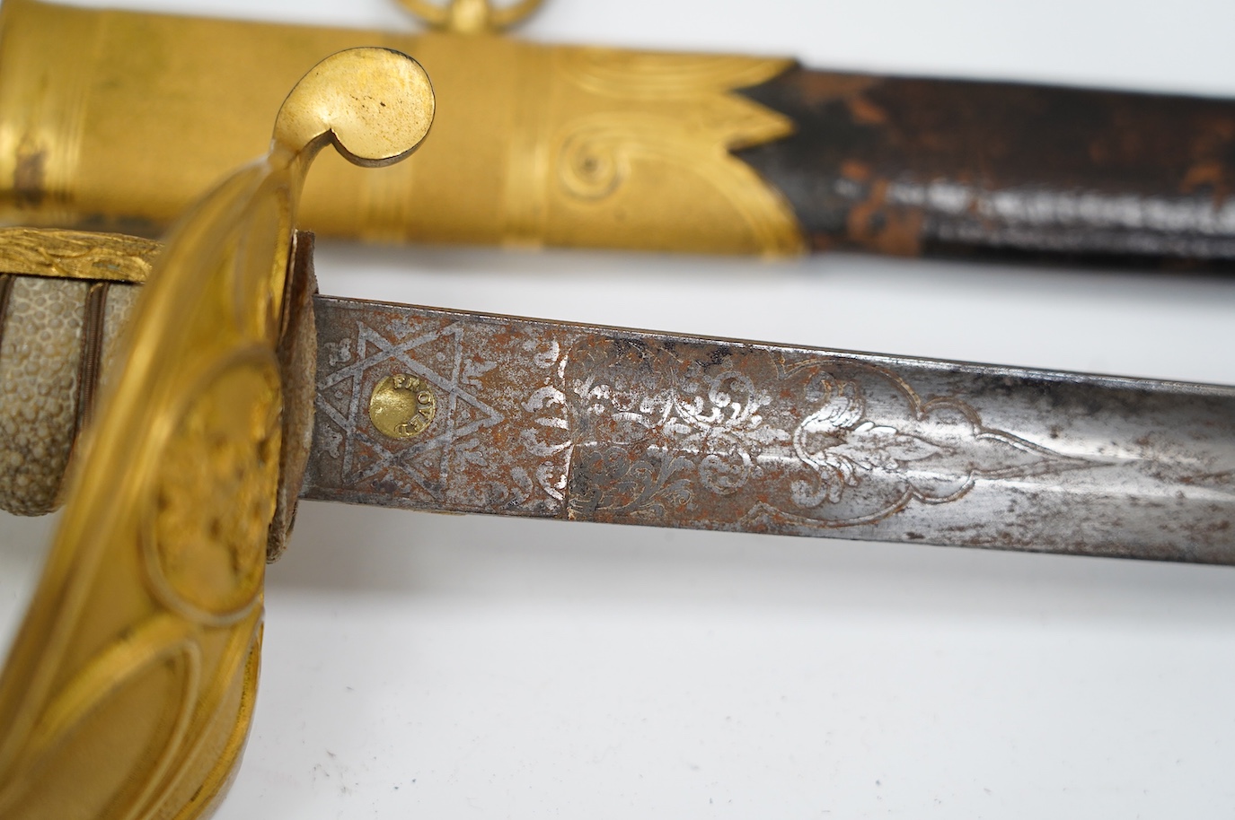 An East India Company naval officer's sword, blade by H. Wart, etched with East India Company device and foliage, regulation gilt, brass hilt with EIC device, white fish skin covered grip, in its leather scabbard with gi